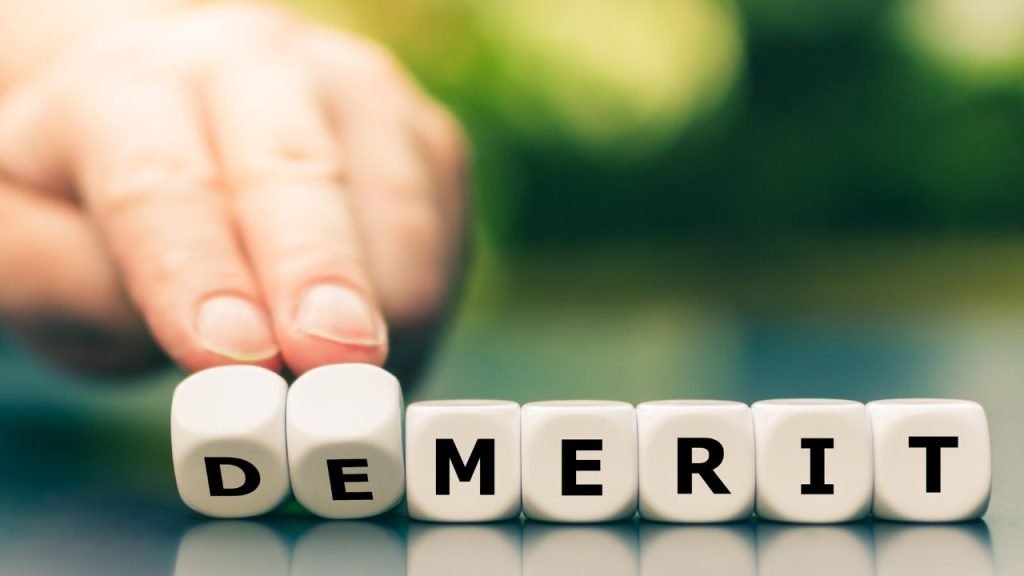 デメリットと英語で書かれたブロック