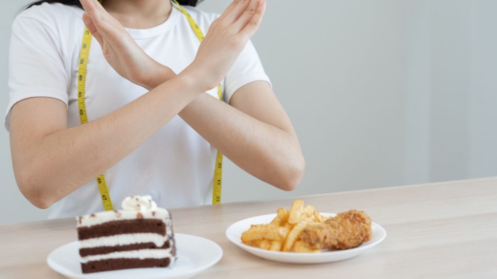 ケーキや揚げ物をダイエットのために拒否する女性