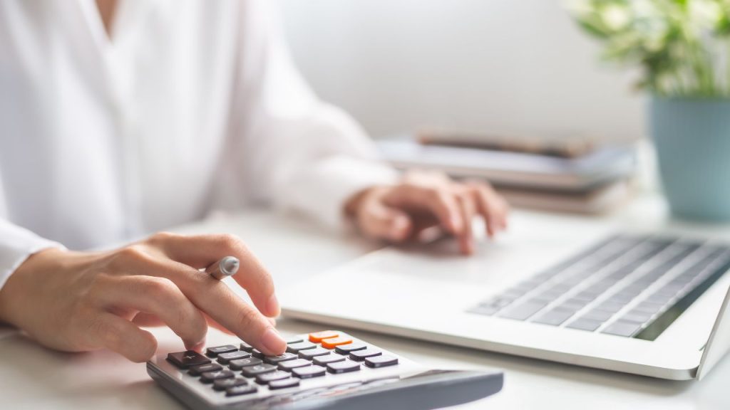 電卓で費用を計算している人