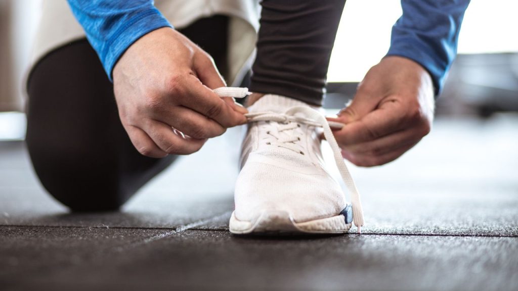 靴紐を結んで走る準備をする男性