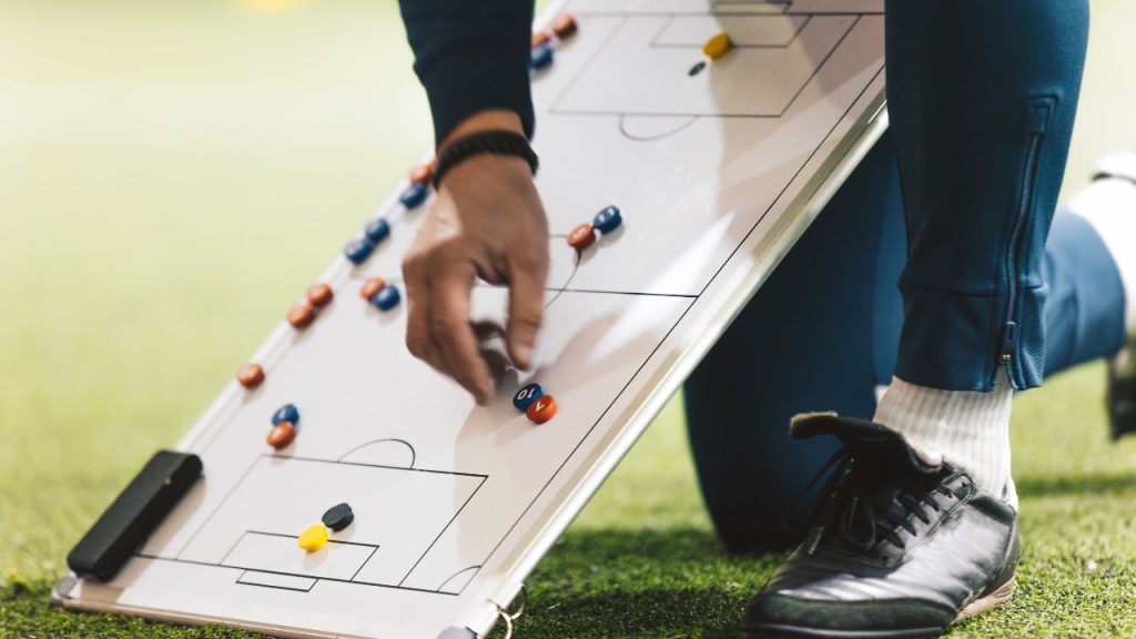 サッカーのコーチがボードを使って戦術を説明している画像